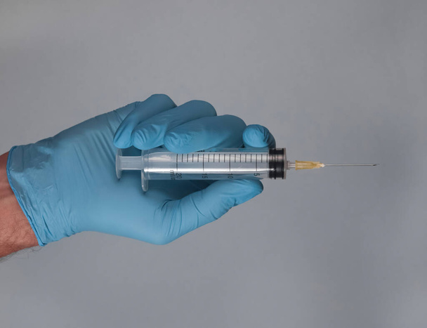 Syringe with needle in doctors hands in glove - Foto, Bild