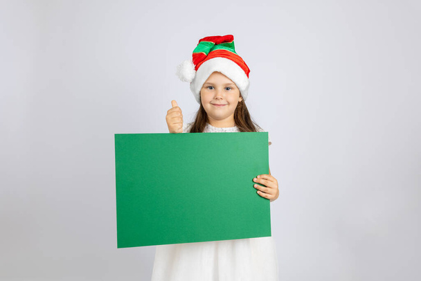 full-length portrait of cheerful girl in white dress and Christmas gnome hat dancing and enjoying holidays, isolated on white background - Photo, Image