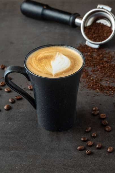 Rentouttava latte kahvia musta posliini kuppi kivi pöydälle - Valokuva, kuva