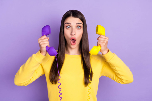 Photo of happy cheerful young shocked woman hold hands head telephone news isolated on purple color background - Photo, Image
