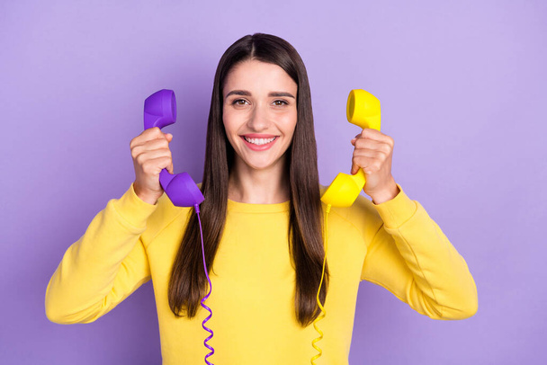 Photo of pretty cheerful young positive woman smile good mood hold hands telephone isolated on purple color background - Photo, Image