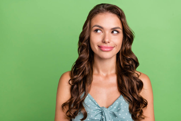 Photo of young attractive girl happy positive smile interested think minded idea look empty space isolated over green color background - Zdjęcie, obraz