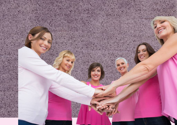 Portrait of group of women stacking their hands together against textured grey background. breast cancer awareness concept - Fotografie, Obrázek