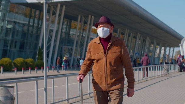 保護顔マスクを身に着けているシニア年金観光祖父は、空港近くのコロナウイルスを避ける - 写真・画像