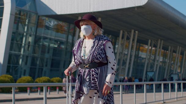 Старша бабуся - пенсіонер, яка носить "Захисне обличчя маска", уникає коронавірусу поблизу аеропорту. - Фото, зображення