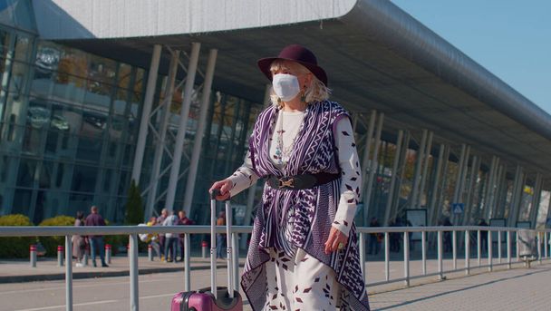 Grand-mère touriste retraitée portant un masque protecteur pour le visage, évitez le coronavirus près de l'aéroport - Photo, image