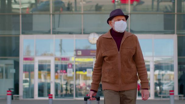 Старший пенсіонер - турист, який носить "Захисне обличчя маска", уникає коронавірусу поблизу аеропорту. - Фото, зображення
