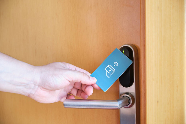 Mano masculina abriendo la cerradura electrónica de la habitación del hotel con una tarjeta de llave. - Foto, Imagen