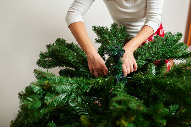Donna irriconoscibile assemblaggio albero di Natale - Foto, immagini