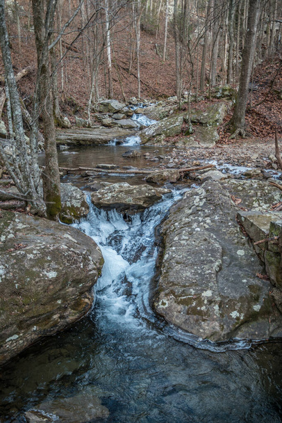 Um riacho fluindo a jusante com gelo formando em torno das pedras nas montanhas do Tennessee na floresta do parque estadual Laurel Snow - Foto, Imagem