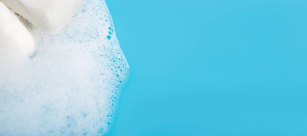 Soap foam on a blue background close-up. Global Handwashing Day. - 写真・画像