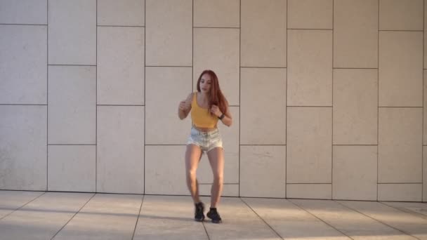 若い赤毛の女性は屋外でヒップホップを踊る。若者のライフスタイル、女性の通りで踊る。魅力的なセクシーな女性ダンサー - 映像、動画