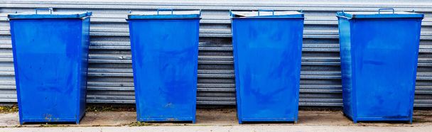 Les poubelles en métal de couleur bleue se trouvent sur une zone spéciale en plein air un jour d'été. Élimination des déchets. - Photo, image