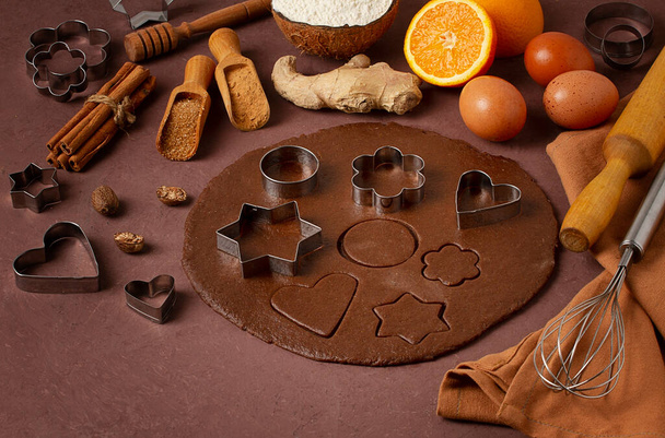 Cookie cutter and gingerbread ingredients, on a wooden table, top view, flat layout, selective focus, vintage toning,. High quality photo - Photo, Image