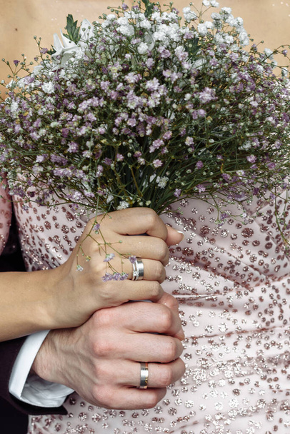 mani di giovani con fedi nuziali. dettagli giorno del matrimonio. fiori di calla. coniugi - Foto, immagini