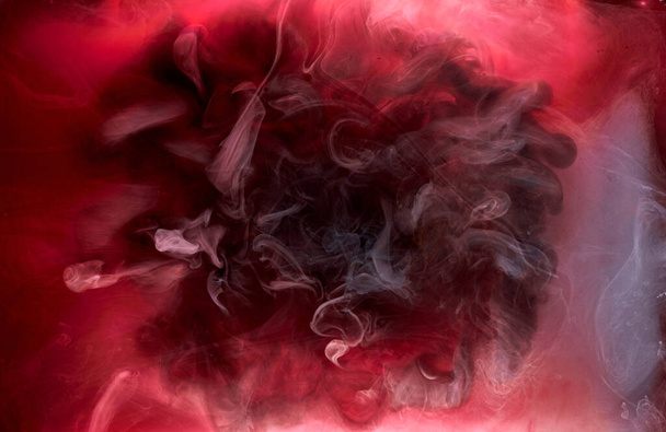 Red black pigment swirling ink abstract background, liquid smoke paint underwater - Zdjęcie, obraz