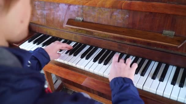 Red-haired guy playing the piano in a blue jacket on the street.frame behind - Footage, Video
