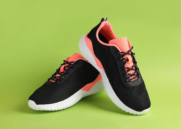 Pair of comfortable sports shoes on light green background - Foto, Bild
