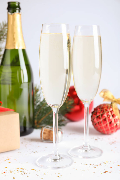 Happy New Year! Glasses of sparkling wine and festive decor on white background - Photo, image