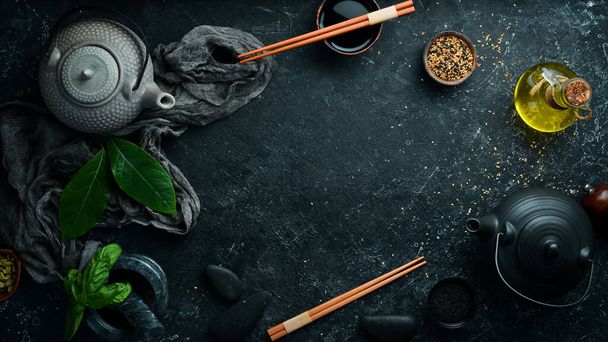Asian food background: plates, sticks and spices on a black stone background. - Fotografie, Obrázek