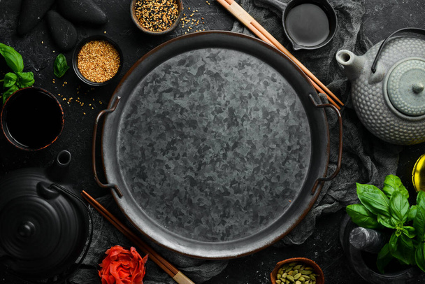 Asian food background: plates, sticks and spices on a black stone background. - Foto, imagen