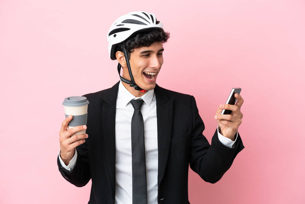 Аргентинський бізнесмен з велосипедними шоломами на рожевому фоні. - Фото, зображення