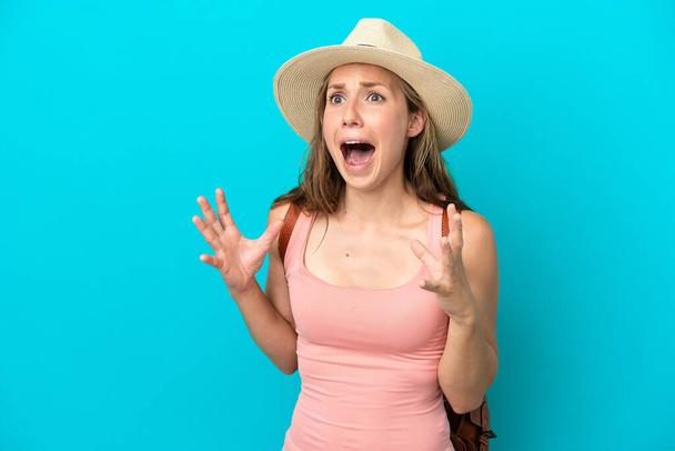 Junge kaukasische Frau in den Sommerferien isoliert auf blauem Hintergrund mit überraschendem Gesichtsausdruck - Foto, Bild