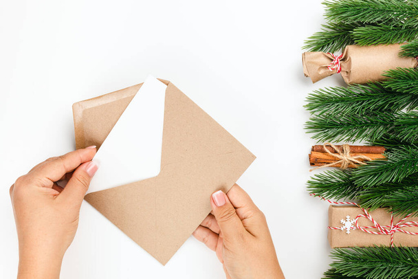 process of writing and sending letter to Santa Claus, craft envelope and frame of Christmas tree branches with gift boxes - Φωτογραφία, εικόνα