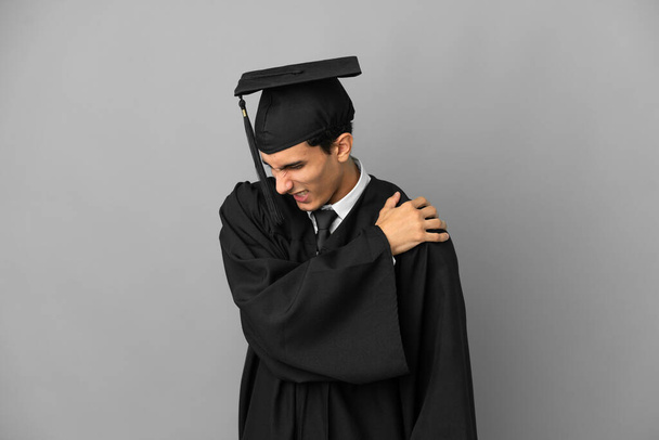 Випускник молодого аргентинського університету, ізольований на сірому фоні, страждає від болю в плечах за те, що зробив зусилля - Фото, зображення