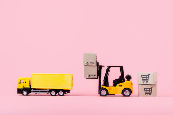 Logistyka i dostawa - Cargo truck, Wózek widłowy i kartonów papierowych lub paczki z logo koszyka na różowym tle. Zakupy w Internecie i oferuje dostawę do domu. z przestrzenią do kopiowania - Zdjęcie, obraz