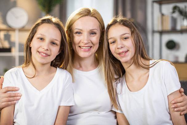 Happy mother embracing daughters during skin care rituals - Foto, immagini