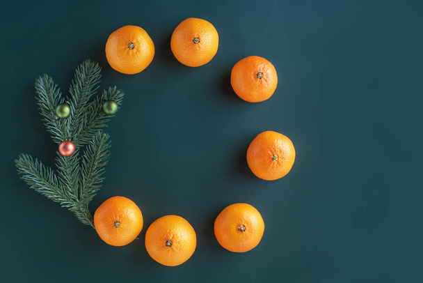 Christmas composition on a green background. Christmas tree with toys and fresh tangerines. - Φωτογραφία, εικόνα