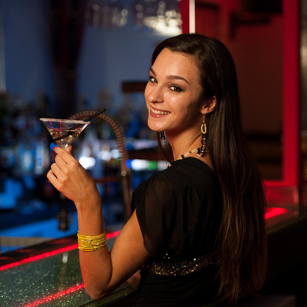 Girl drinks a cocktail in night club - Фото, зображення