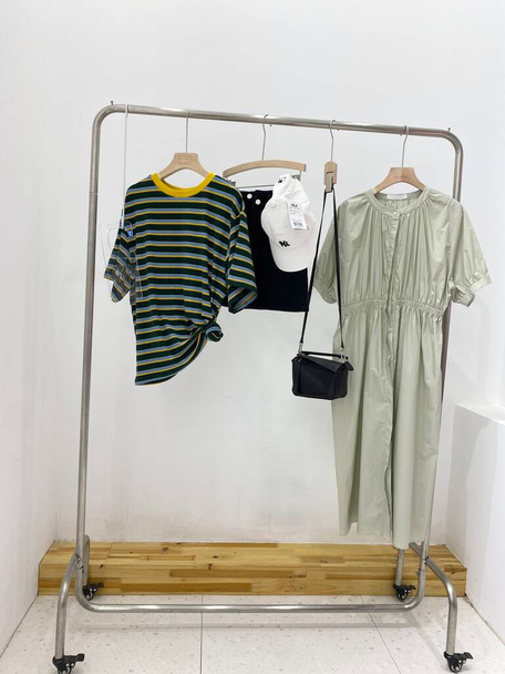 rack with clothes and hangers on hanger on gray background - Foto, imagen