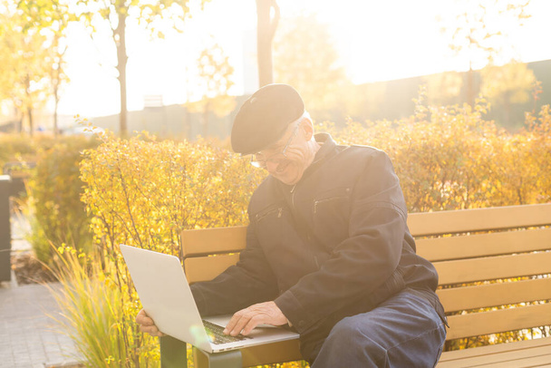 Elderly man use laptop in the park. Handsome senior man in glasses work outside. - Fotografie, Obrázek