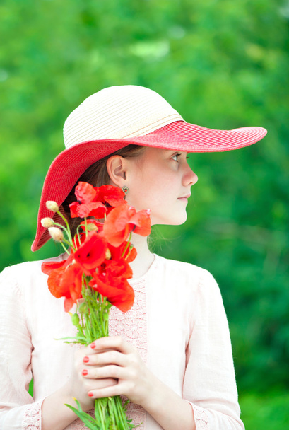 Jovem bela senhora em chapéu vermelho com buquê de flores de papoula
. - Foto, Imagem