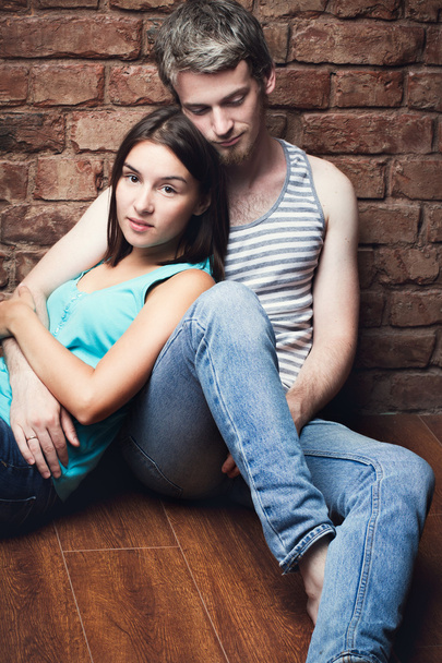 junges Paar sitzt auf dem Fußboden  - Foto, Bild