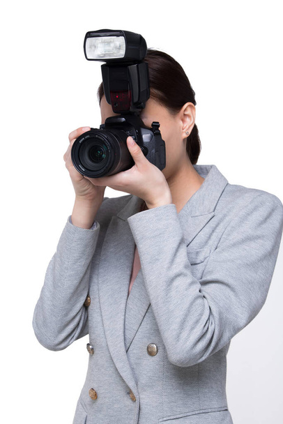 Asian Woman Photographer hold camera with external flash point to shoot subject, wear formal black suit. studio lighting white background isolated copy space, reporter journalist take photo celebrity - Foto, Bild