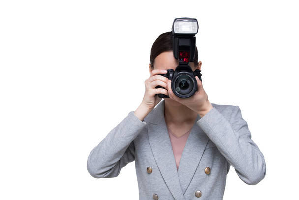 Ázsiai nő fotós tartsa kamera külső flash pont lőni téma, viseljen formális fekete öltöny. stúdió világítás fehér háttér elszigetelt másolás tér, riporter újságíró fotózás híresség - Fotó, kép