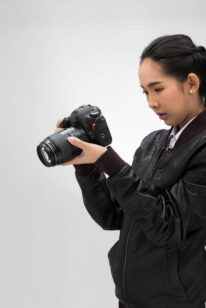 Φωτογράφος κρατήσει φωτογραφική μηχανή με το σημείο φακό για να πυροβολήσει το θέμα, φορούν κανονική σκούρο μαύρο σακάκι leater κοστούμι. στούντιο φωτισμού λευκό κλίση γκρι φόντο απομονωμένο, δημοσιογράφος λάβει φωτογραφία διασημότητα - Φωτογραφία, εικόνα
