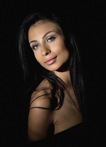Glamorous woman with black hair on dark background - Fotoğraf, Görsel