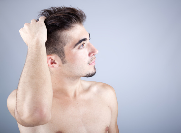 pohledný muž dotýká vlasy - Fotografie, Obrázek