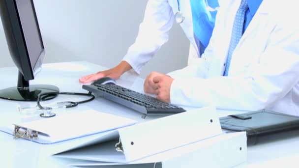 lääkärit käyttävät tietokonetta lääketieteellisessä toimistossa
 - Materiaali, video
