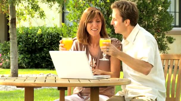 Casal em casa jardim com computador portátil
 - Filmagem, Vídeo