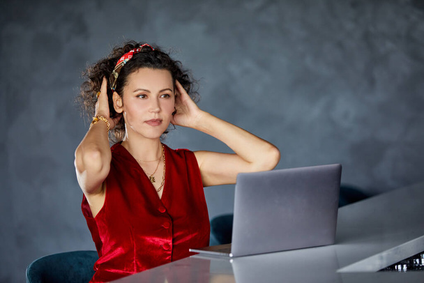 Beautiful elegant curly woman using laptop while sitting in cafe. Blogger concept - Photo, Image