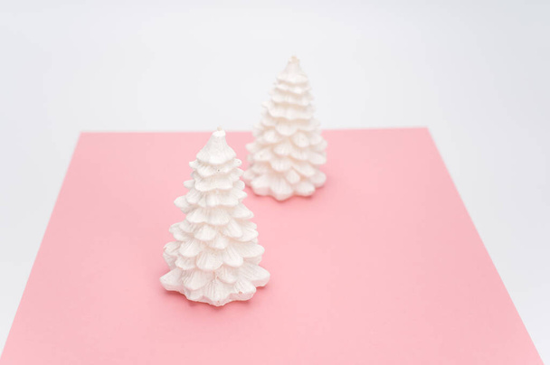 Christmas ornamental background with fir trees on a pink and white surface with copy space - Fotografie, Obrázek