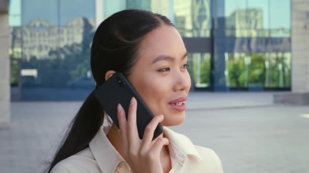 Mujer de negocios coreana hablando por celular en el área urbana al aire libre - Metraje, vídeo