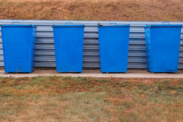 Blaue Metallmülltonnen stehen an einem Sommertag auf einer speziellen Fläche im Freien. Abfallentsorgung. - Foto, Bild