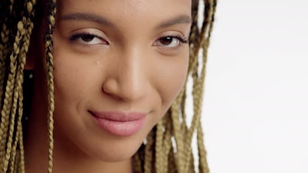 Retrato de sonriente hembra negra con peinado trenzado, fondo blanco - Metraje, vídeo