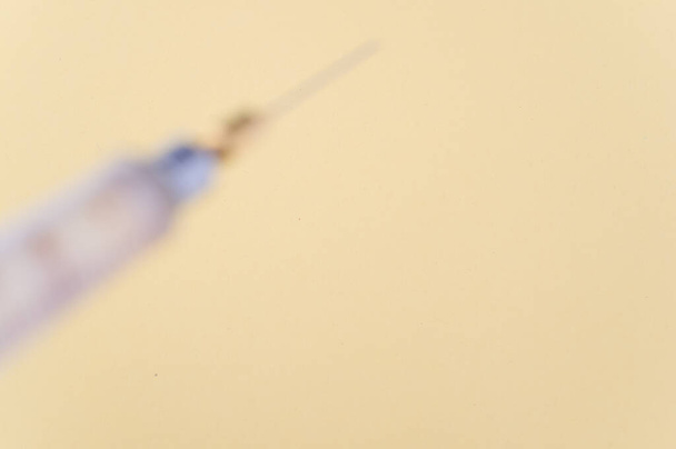 an isolated injection syringe on yellow paper background with text space - Foto, Bild